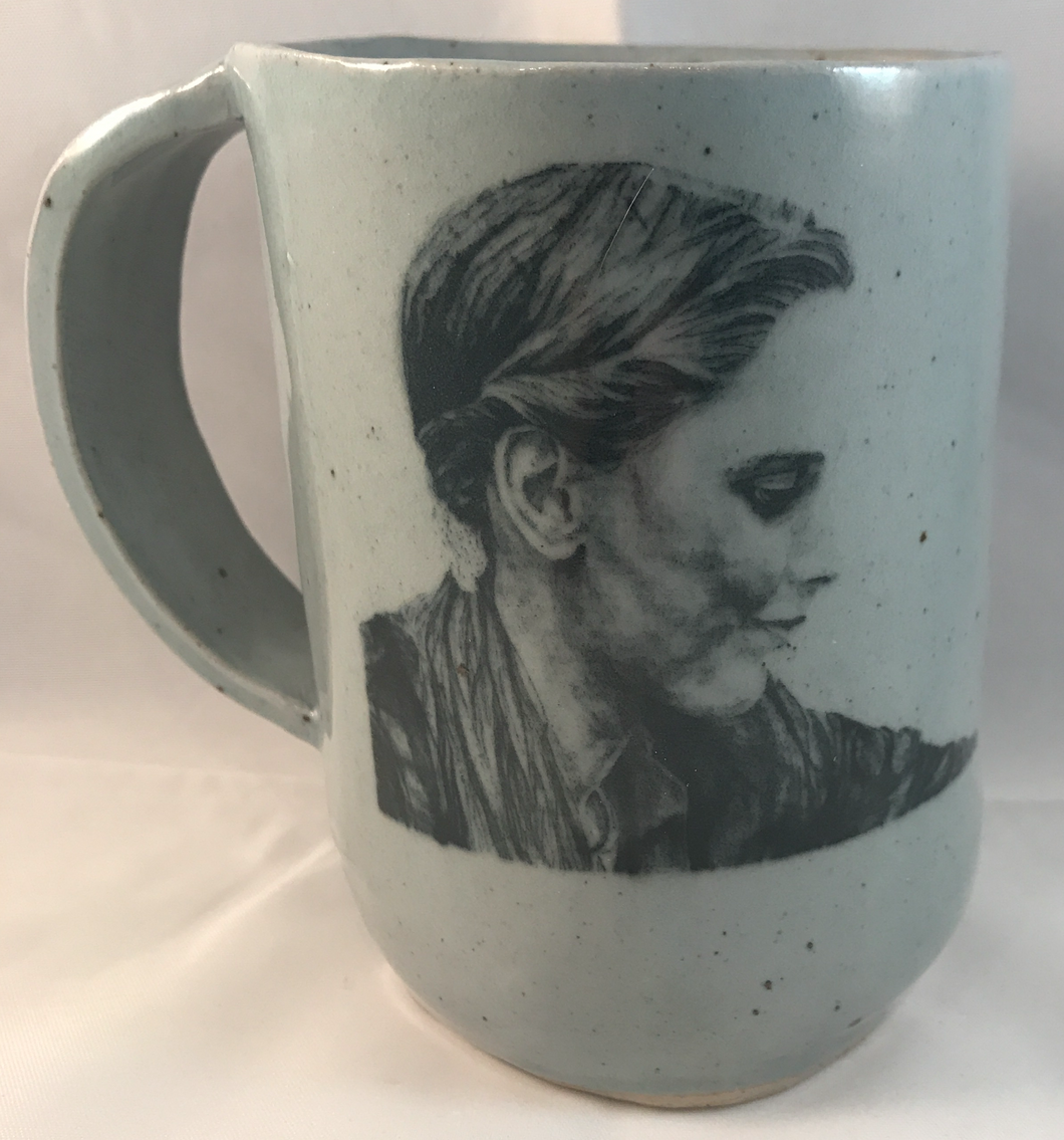 Light turquoise handmade mug with a black and white portrait of Rachael Denhollander